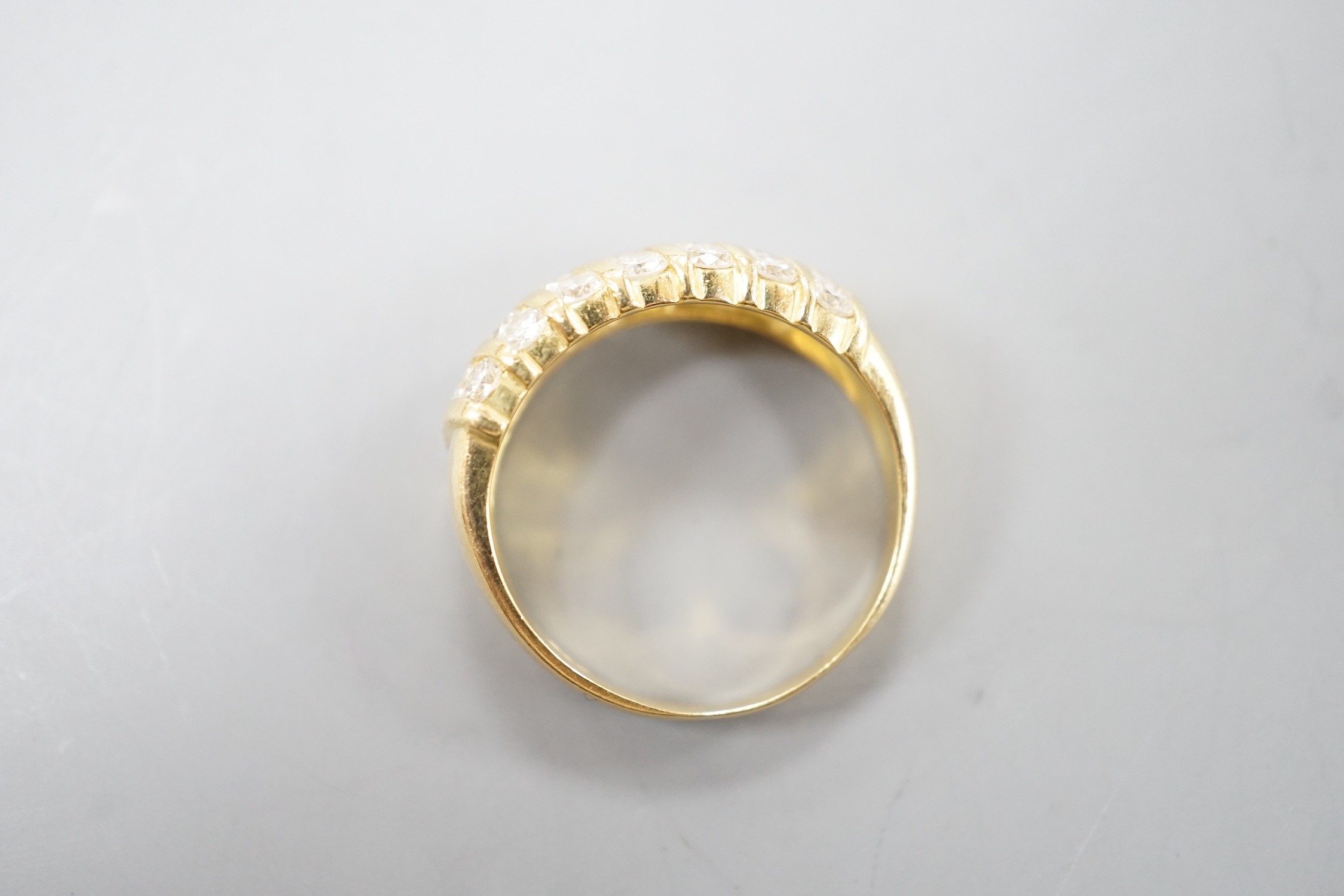 A modern 18ct gold and twenty one stone diamond set seven row half hoop ring, size N, gross weight 4.5 grams.